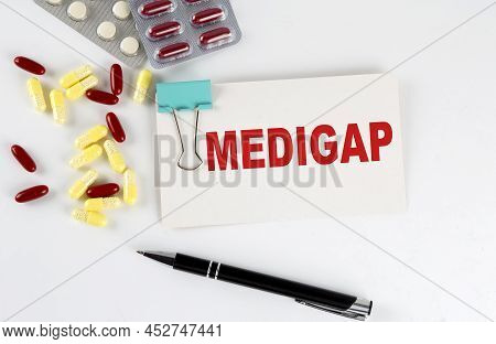 Medigap Text Written In Card With Pills. Medical Concept.