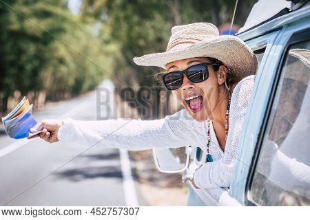 Overjoyed Adult Pretty Woman Outside The Window Of Her Classic Car With Guida Map On Hand Asking Hel