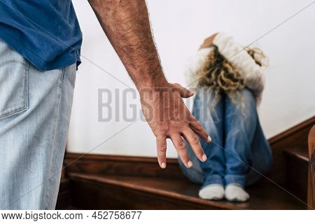 Domestic Violence Aggression Concept With Hidden Woman Protecting Herself From Angry Man Ready To Hi