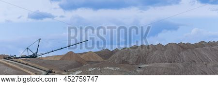 Giant Spreader Or Absetzer Machinery. A Large Dumper On A Landfill With Potash Ore. Extracting And M