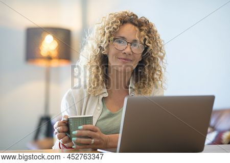 Adult Woman Work At Home Drink Relaxed And Use Laptop Computer - Smart Working Alternative Freedom O