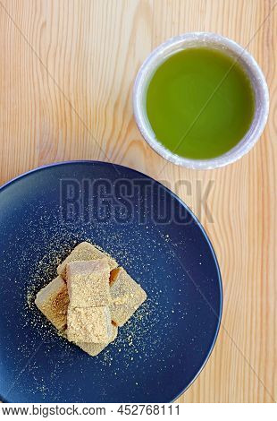 Plate Of Warabimochi, Japanese Traditional Confection With A Cup Of Hot Matcha Green Tea