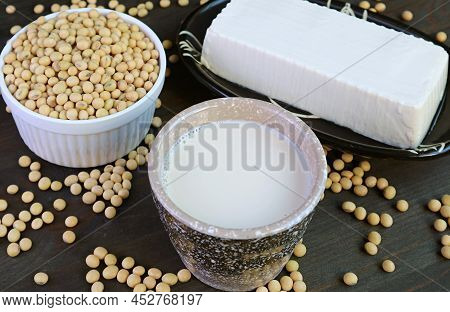 Cup Of Soy Milk With Soft Tofu Bean Curd And Dried Soybeans Pile In The Backdrop