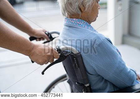 Caregiver Help And Care Asian Senior Or Elderly Old Lady Woman Patient Sitting On Wheelchair At Nurs