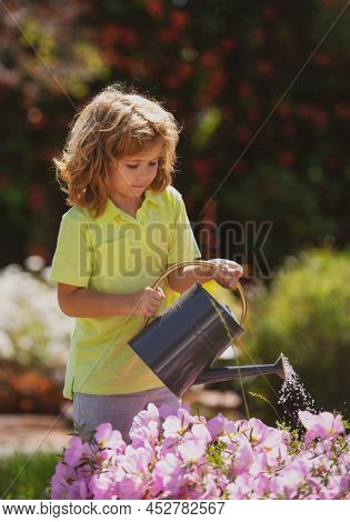 Active Kid Watering Plants On Backyard. Child Helping Arents To Grow Herbs And Flowers In Garden.