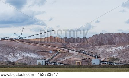 Giant Spreader Or Absetzer Machinery. A Large Dumper On A Landfill With Potash Ore. Extracting And M