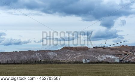 Giant Spreader Or Absetzer Machinery. A Large Dumper On A Landfill With Potash Ore. Extracting And M