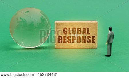 Technology And Business Concept. On The Green Surface Is A Globe And A Figurine Of A Man Who Looks A