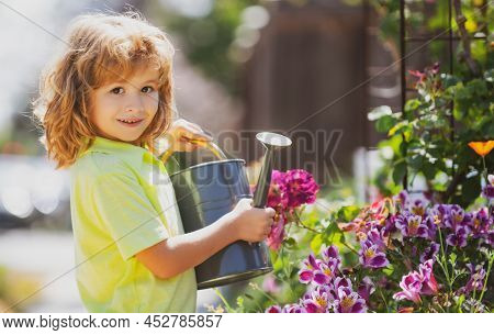 Active Kid Watering Plants On Backyard. Child Helping Arents To Grow Herbs And Flowers In Garden.