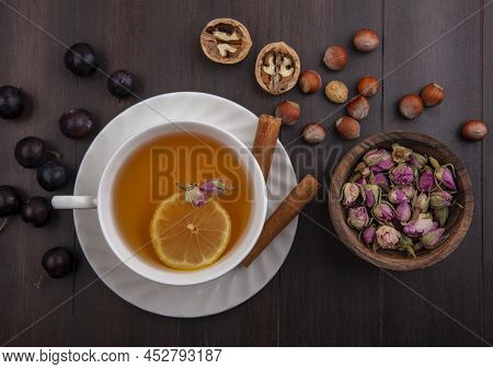 Top View Of Cup Of Hot Toddy With Lemon Flower Inside And Cinnamon On Saucer With Pattern Of Sloe Be