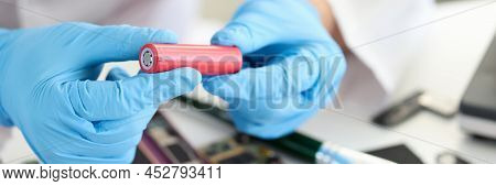 Master Holding Electronic Battery Near Microchips In Workshop Closeup. Replacement Of Batteries In M