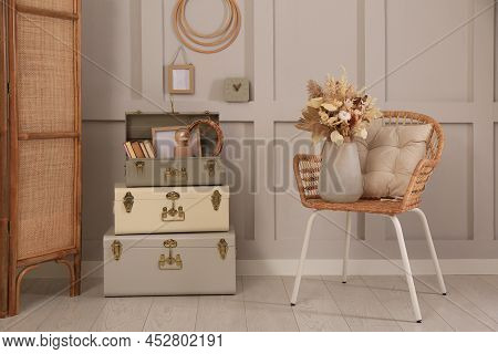 Wicker Chair With Dry Flowers And Storage Trunks Indoors. Interior Design