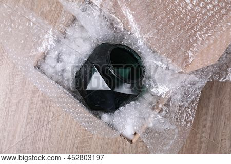 Glass Vase With Bubble Wrap And Packaging Foam In Cardboard Box On Wooden Table, Top View