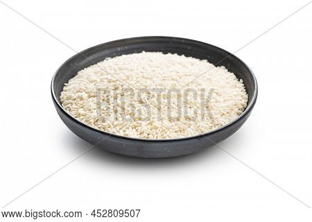 Uncooked Carnaroli risotto rice in bowl isolated on a white background.