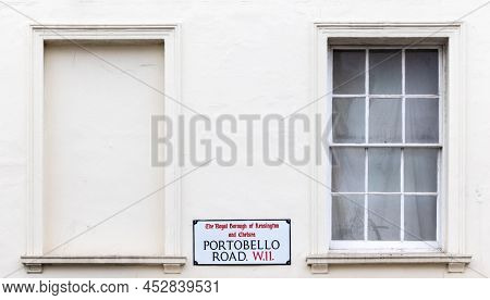 Street sign on a white painted wall, Portobello Road, London. Site of the famous street market. Wto window recesses with space for text. 