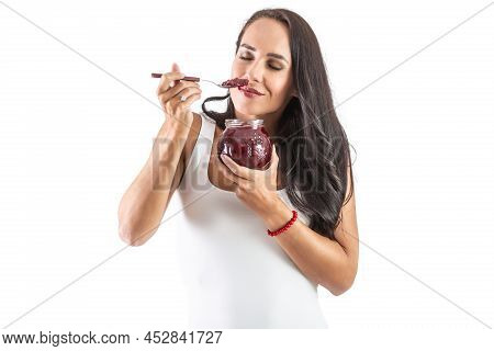 Charming Brunette Is Holding A Spoon Sull Of Jam And Smelling The Tasty And Sweet Aroma. Isolated Ba