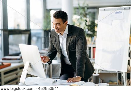 Hispanic Male Boss Discussing New Business Strategy With Employees, Talking About Future Plans Of Co
