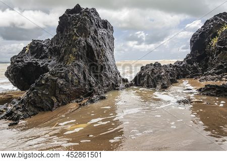 Black Dark Boulders Lying On A Beach After The Coast In Axim Ghana West Africa