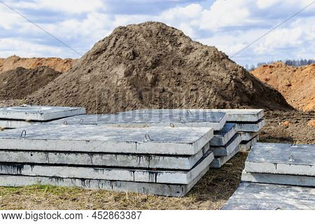 Reinforced Concrete Slabs At A Construction Site Against A Blue Cloudy Sky And Earth. Folded Plates 