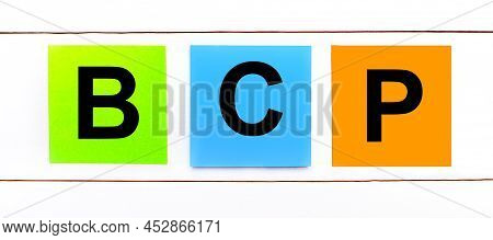 On A White Wooden Background There Are Three Colorful Bright Stickers With Text Bcp Business Continu