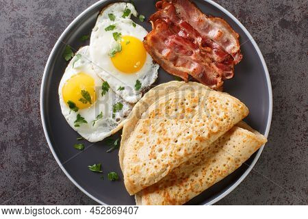 Delicious Oatcakes Served With Egg And Bacon Close-up In A Plate On The Table. Horizontal Top View F