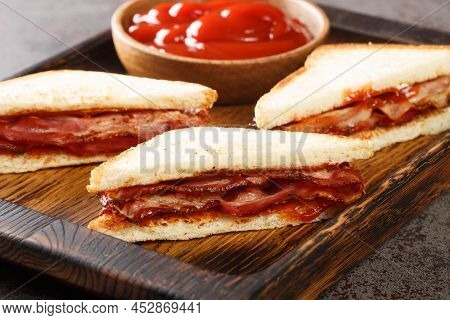 Bacon Butty Sandwich With Ketchup Closeup In The Wooden Tray On The Table. Horizontal