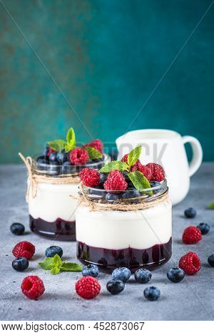 Parfait With Cream Or Yogurt, Jam And Fresh Berries In The Glass Jar. Close Up. Healthy Dessert Or S