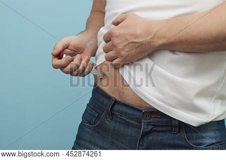 Man Doing Insulin Injection Pen, Close-up, Blue Background