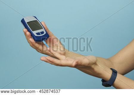 Woman Checking Blood Sugar Level With Glucometer