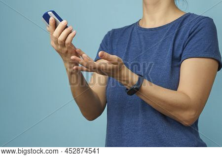 Woman Checking Blood Sugar Level With Glucometer