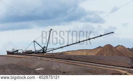 Giant Spreader Or Absetzer Machinery. A Large Dumper On A Landfill With Potash Ore. Extracting And M