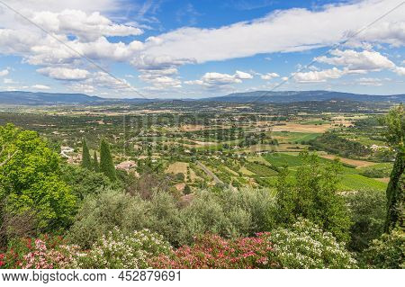 Breathtaking View Of Luberon Valley Under Blue Sky With White Clouds, Summer Day Blossoming Trees Ri