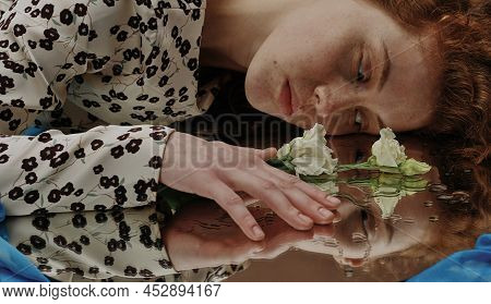 Young Red Haired Woman Lying And Looking At Mirror With Sensual Expression