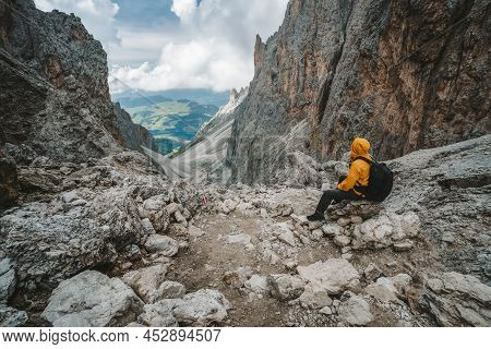 Man Hiker Taking Rest At Pass On Mountain Sassolungo - Langkofel, Alpe Di Siusi, Dolomiti Mountain -