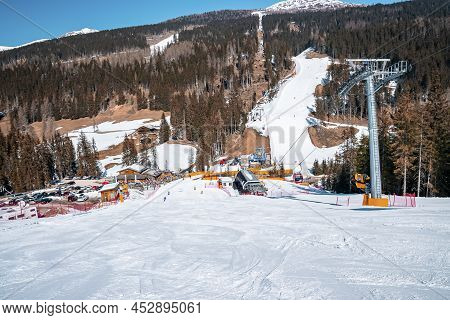 Ski Tracks On Snow Covered Landscape Against Trees In Forest At Alps