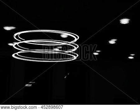 Ruti, Switzerland - April 8, 2021: Monochrome Photo Of A Large Circular Halogen Room Lamp And Its Re