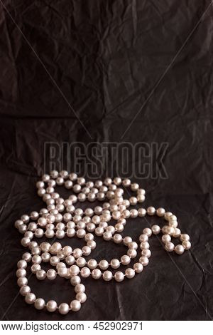 Feminine Desktop Mockup With Pearls On Black Paper Background With Copy Space.