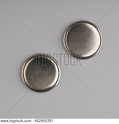 Round Batteries On A Gray Background. Closeup