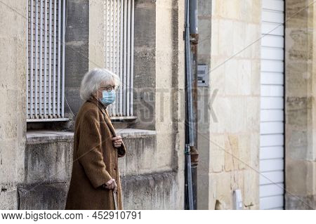 Bordeaux, France - February 24 2022: Selective Blur On Old Woman With Facemask, Standing In A Street