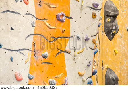 Artificial Rock Climbing Wall With Various Colored Grips.