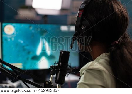 Concentrated Pro Gamer Talking Into Microphone During Live Streaming While Playing Online Video Game