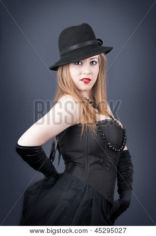 Chica de pie en un sombrero negro