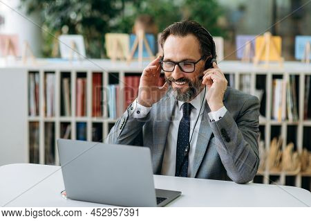 Smiling Male Operator Of Call Center In Headphones Communicate With Clients, Consulting People. Seni