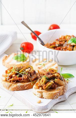 Traditional Italian Caponata And Toast On A Wooden White Table. Sicilian Caponata.