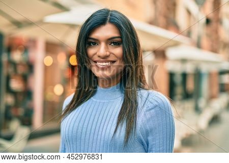 Beautiful hispanic woman smiling confient at the city