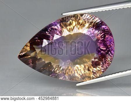 Natural Gemstone Colored Ametrine In Thongs On A Gray Background. Natural Bolivian Bicolor Yellow Pu