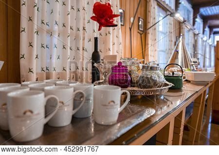 Assorted Teacups And Glass Jars In Trays On Counter For Breakfast At Restaurant