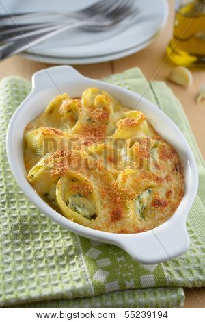 Baked lumaconi with ricotta, spinach, and grated Parmesan cheese