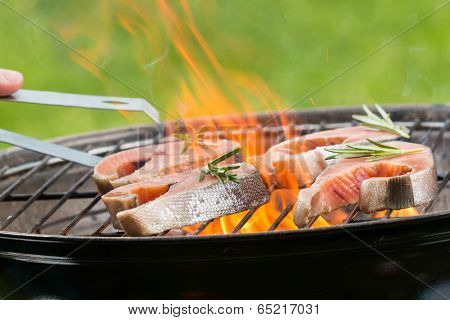 Delicious grilled salmon steaks on fire