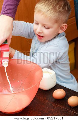 Boy Kid Baking Cake. Child Pouring Mik Into A Bowl. Kitchen.